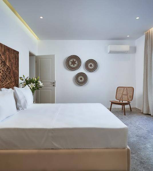 The king-size bed of the UBUD Mykonos superior room with garden view
